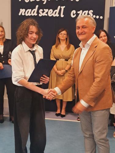 Wójt Gminy Łączna wręcza stypendium uczeniowi klasy 7 Jakubowi Gilowi.