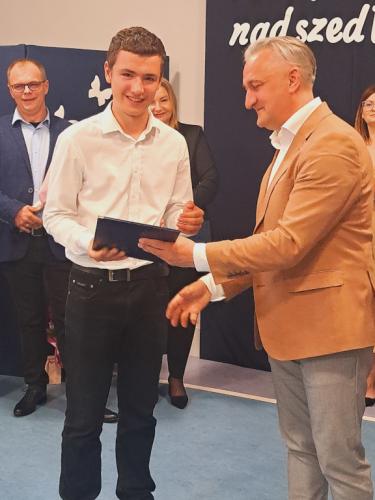 Wójt Gminy Łączna wręcza stypendium uczniowi klasy 7 Krzysztofowi Saletrze.