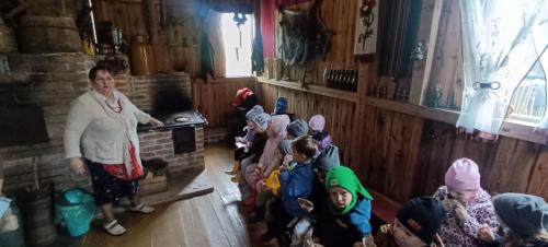 Pani Grażynka wraz z przedszkolakami podczas wypiekania podpłomyków 